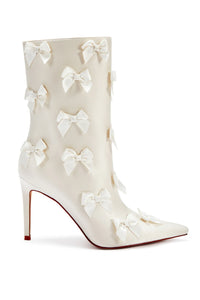 side view of coquette pointed toe bow stiletto  bootie - featured in ivory in front of a plain white background - perfect for brides to be, birthday dinners and more