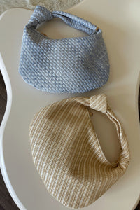 tan straw woven shoulder bag and denim blue woven knotted purse