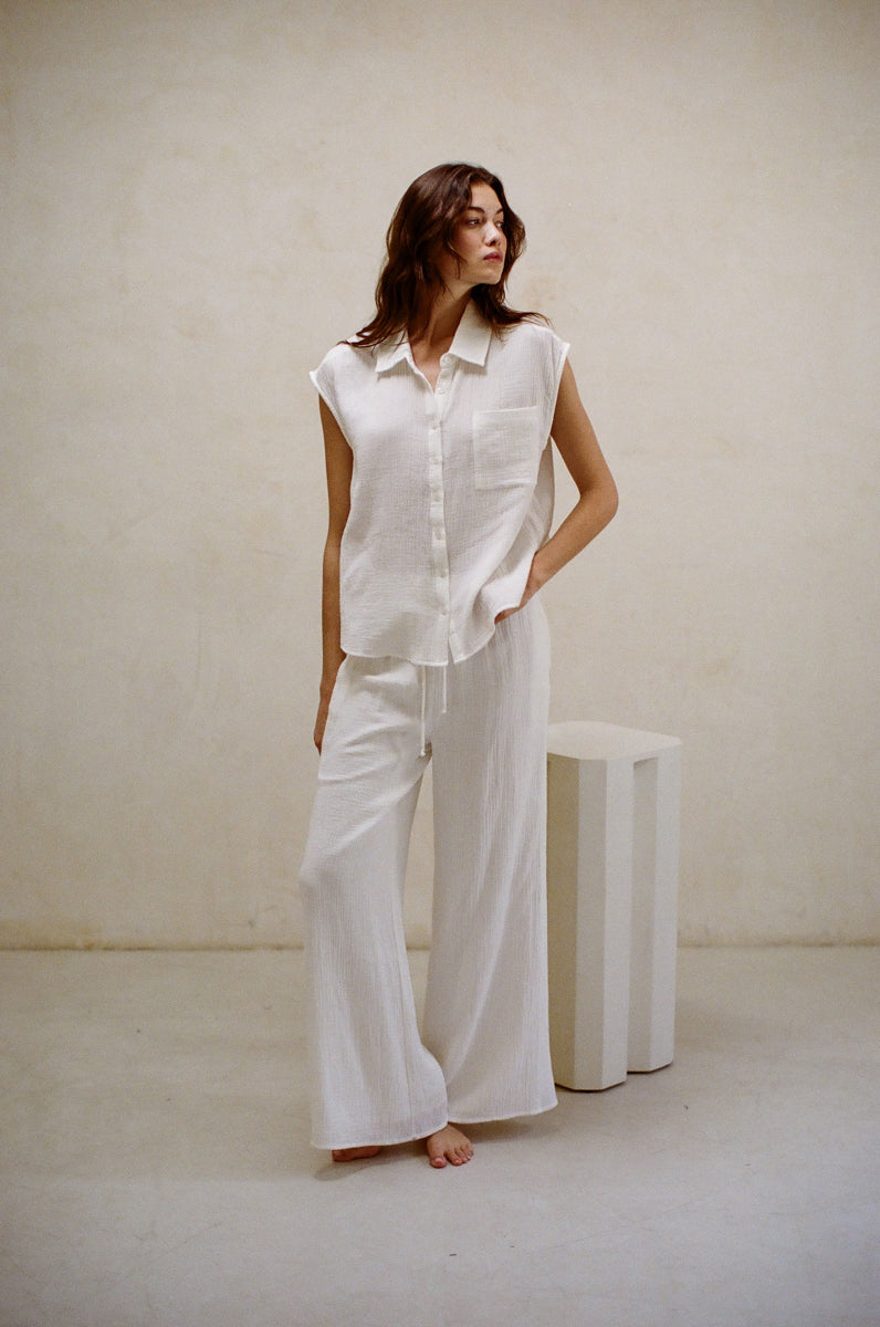 white gauze material matching set - sleeveless collared button up shirt and wide leg pants - resort wear