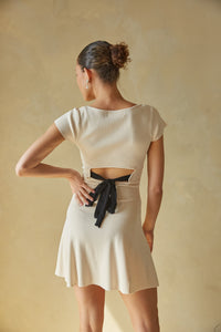 cream and black contrast mini dress with open back and bow detailing