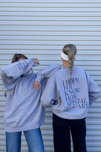 gray sweatshirt with navy blue cuff details and back graphic that reads "I hope you know how special you are" | Trendy Holiday Christmas Gift Ideas 2023 | Charitable Fashion Brands