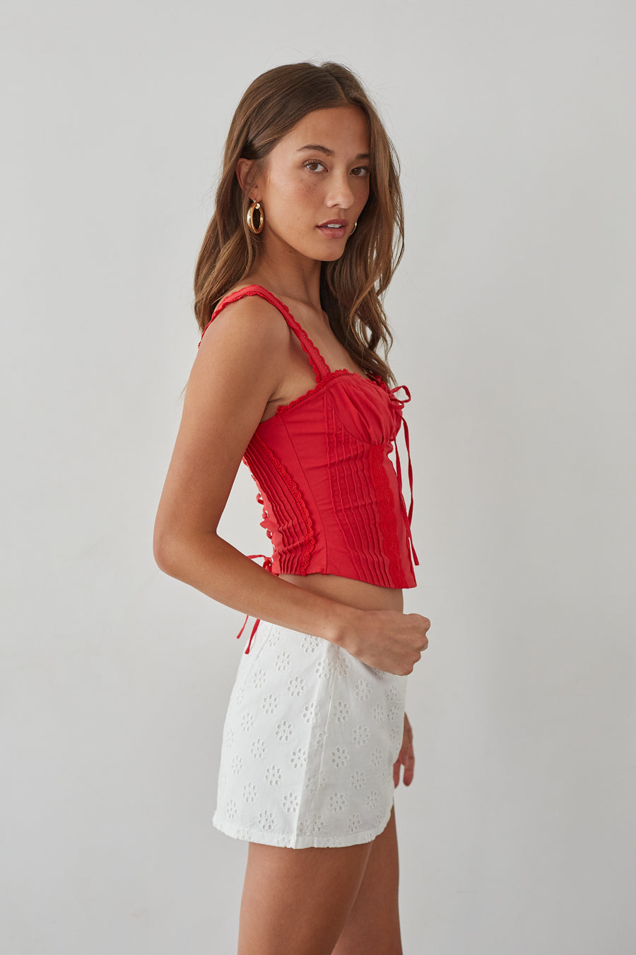 side-image | lace detail corset cami | fitted ruched bust top | date night summer tops | red corset crop top with delicate lace trim and side ruching