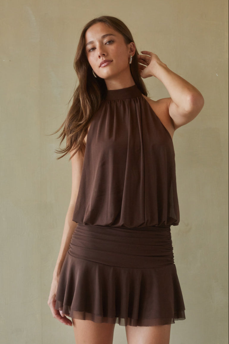 brown-image | Woman wearing a brown sleeveless top and skirt against a beige background