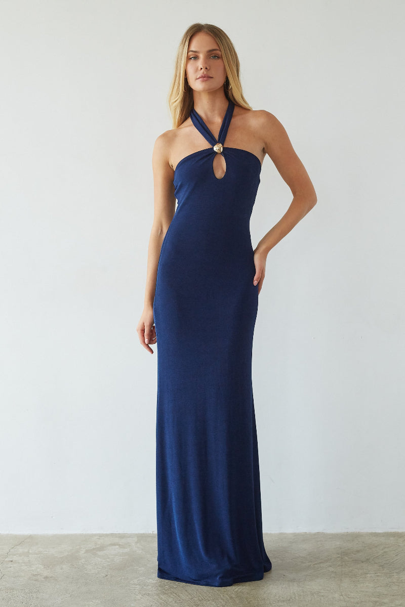 blue-image | Woman wearing a navy blue halter neck gown against a plain background