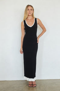 Woman wearing a black dress with white trim against a white background