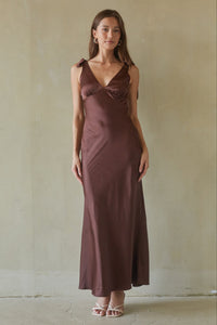 brown-image | Woman wearing a brown dress against a plain background