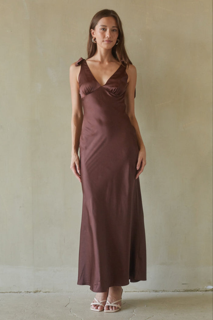 brown-image | Woman wearing a brown dress against a plain background