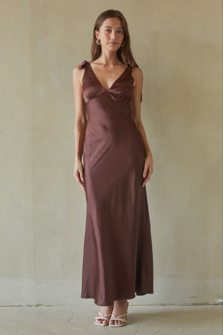 brown-image | Woman wearing a brown dress against a plain background