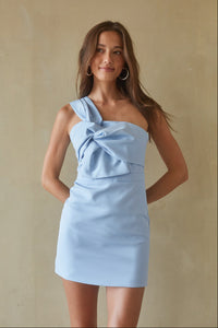 A woman in a light blue one-shoulder bodycon mini dress from American Threads, perfect for homecoming or formal events.