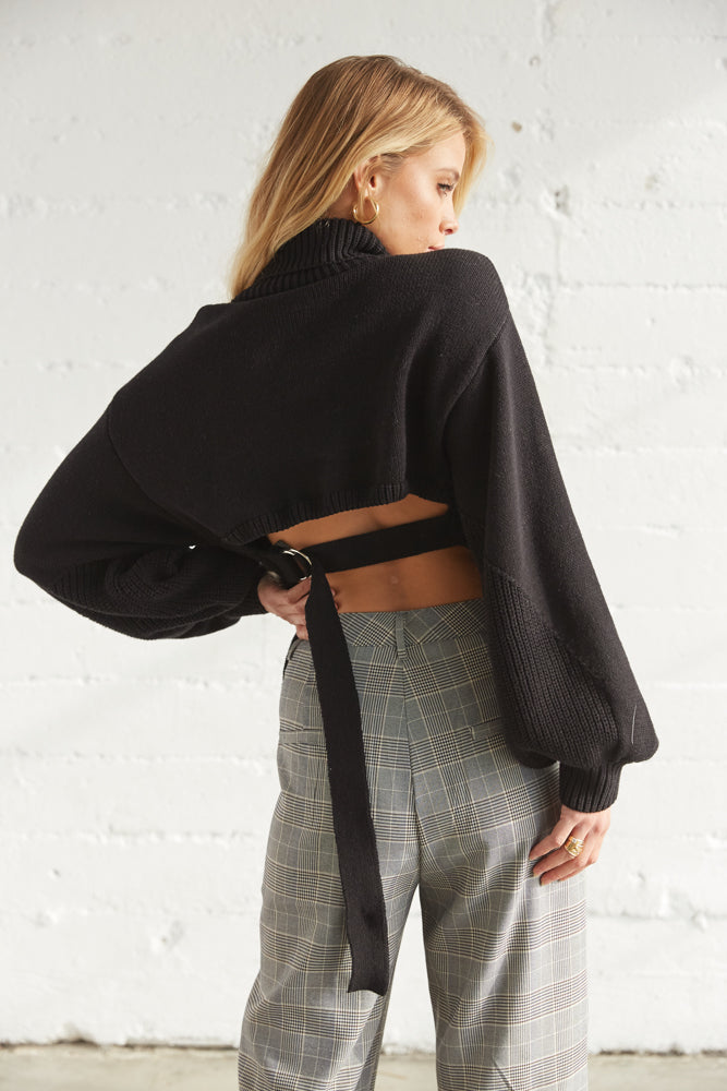 The back of this sweater is open with a belted design. 