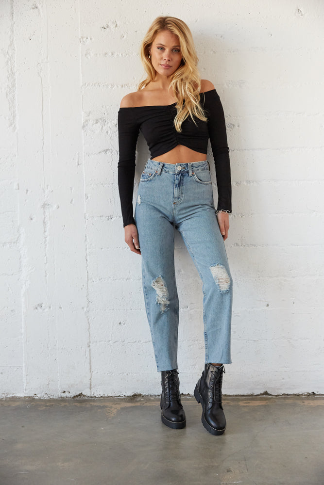 Medium wash high waisted jeans with a black crop top and combat boots. 