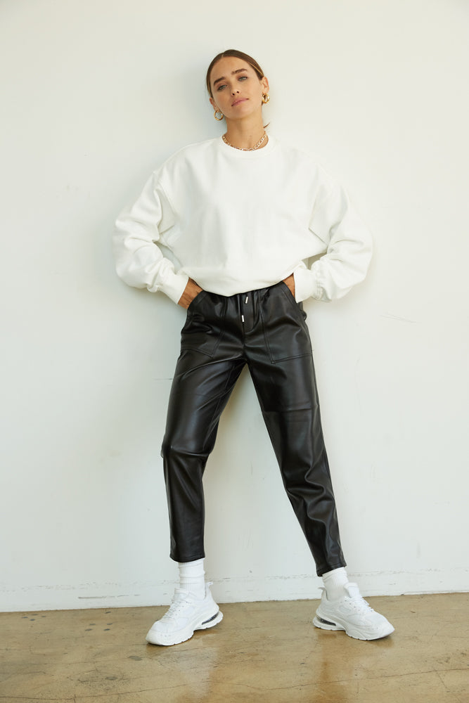 Black vegan leather pants with white sweatshirt. 