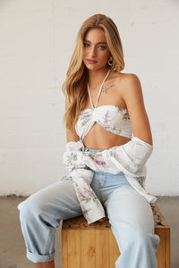 Model posing in white floral crop top