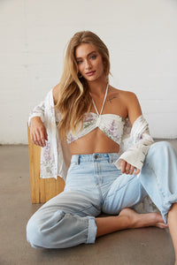 Model sitting in white floral eyelet top