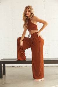 Model posing in brown wide leg pants set