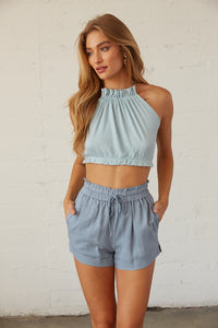 Front view of blue knit open back top